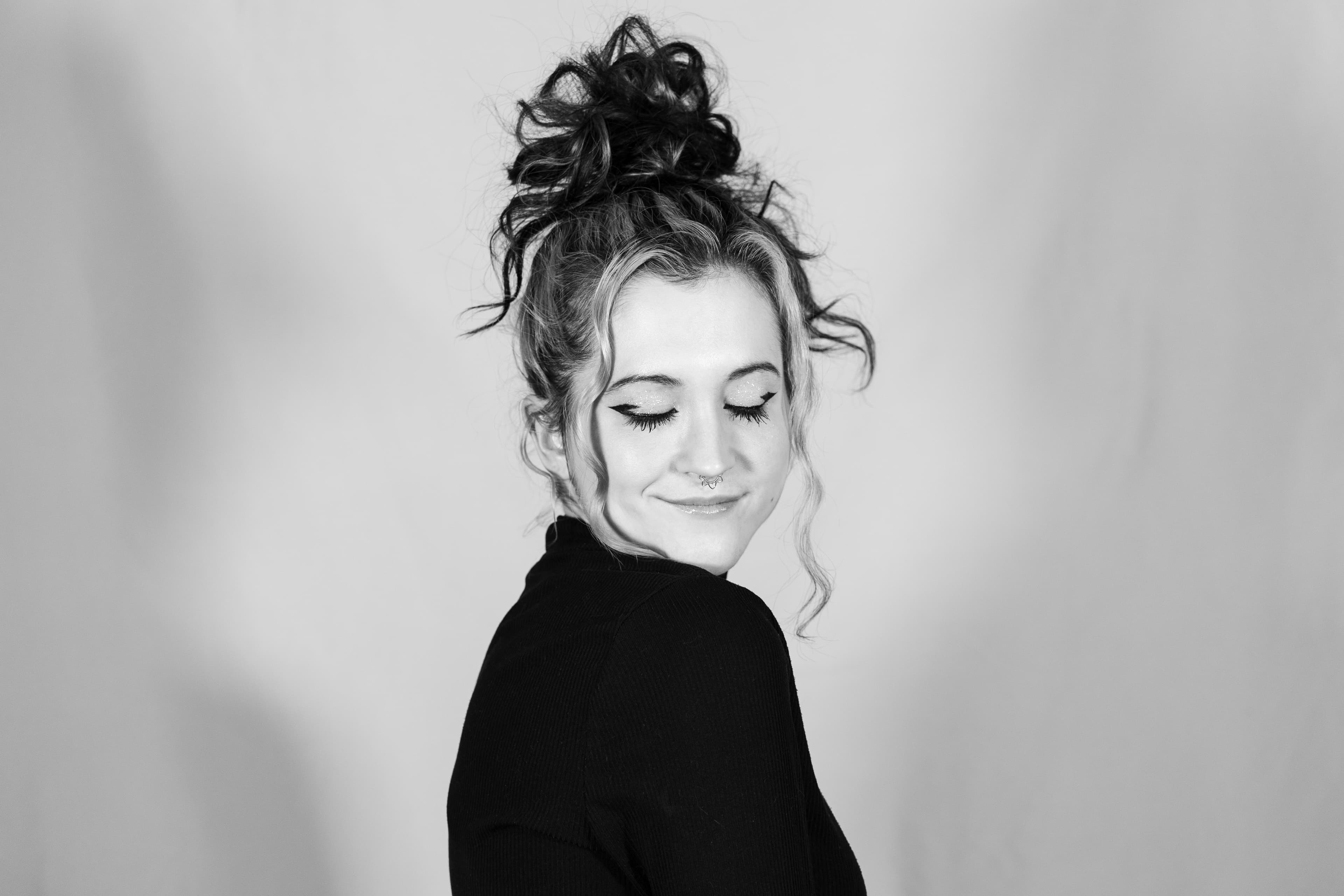 Woman looking over shoulder with eyes closed