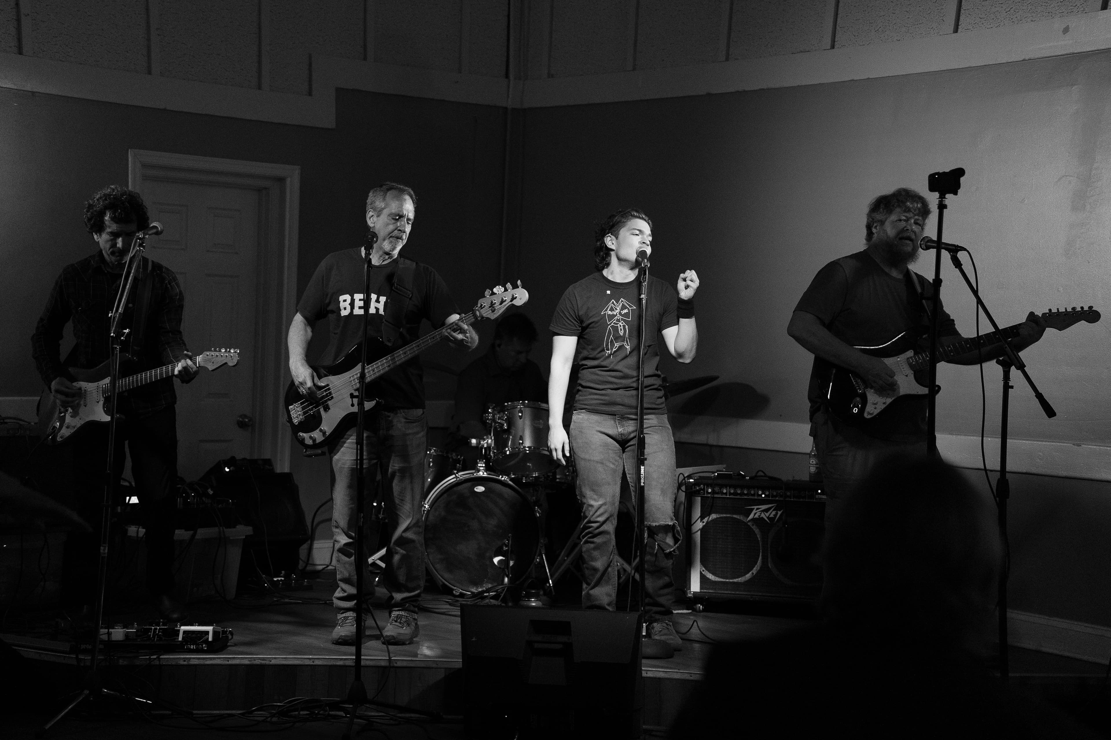 A band plays on stage in black and white.