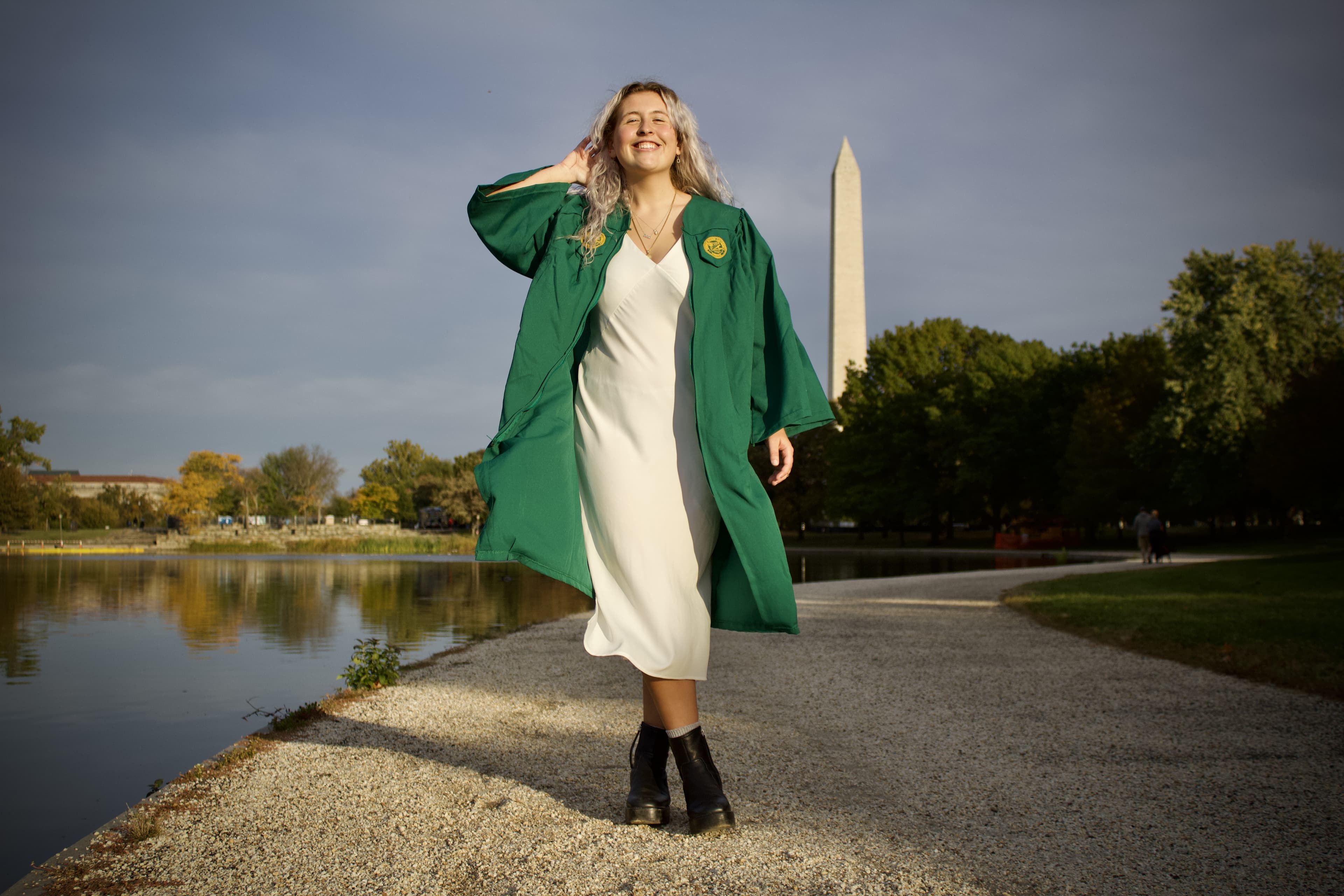 A college grad poses in front of the Washington Monument.
